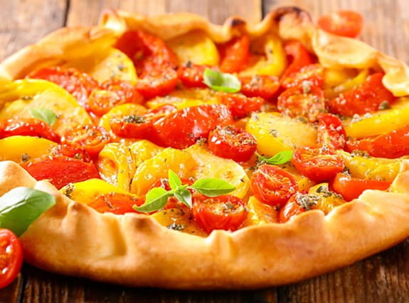 A close up image of a phyllo tart with tomatoes on it