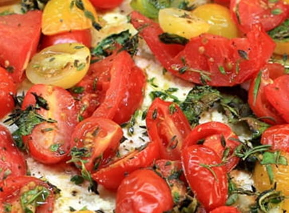 A close up image of a phyllo tart with tomatoes on it