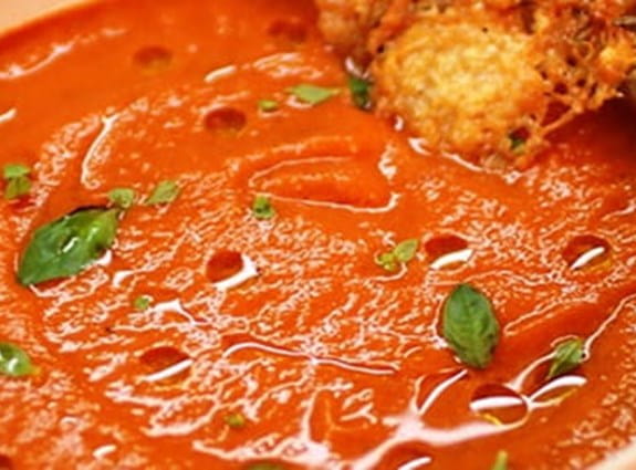 Bol de soupe aux tomates accompagné d’une rôtie.