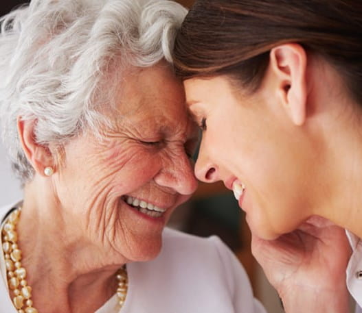 Femme âgée touchant le visage d'une jeune infirmière