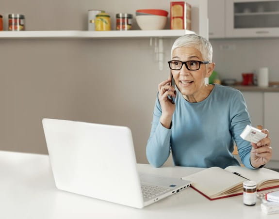 A woman on a phone holding medication