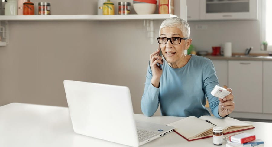 A woman on a phone holding medication