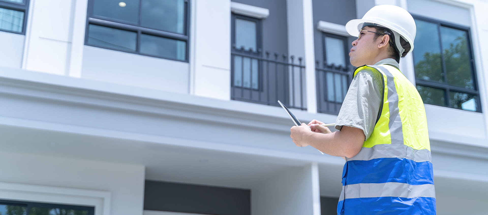Person in safety gear is inspecting the exterior of a modern building