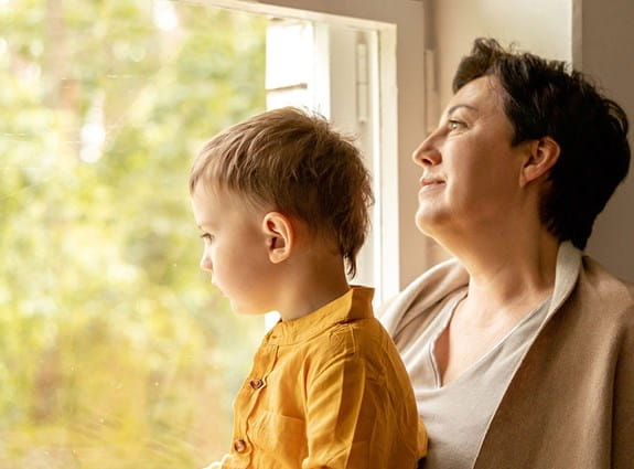 a women and a child looking out the window
