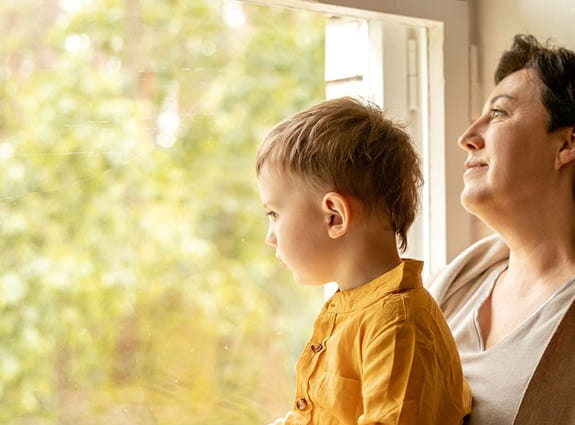 une femme et un enfant regardant par la fenêtre