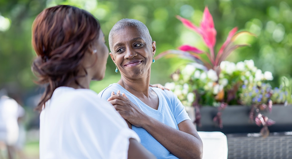 Deux personnes assises dehors en train de discuter entre elles.