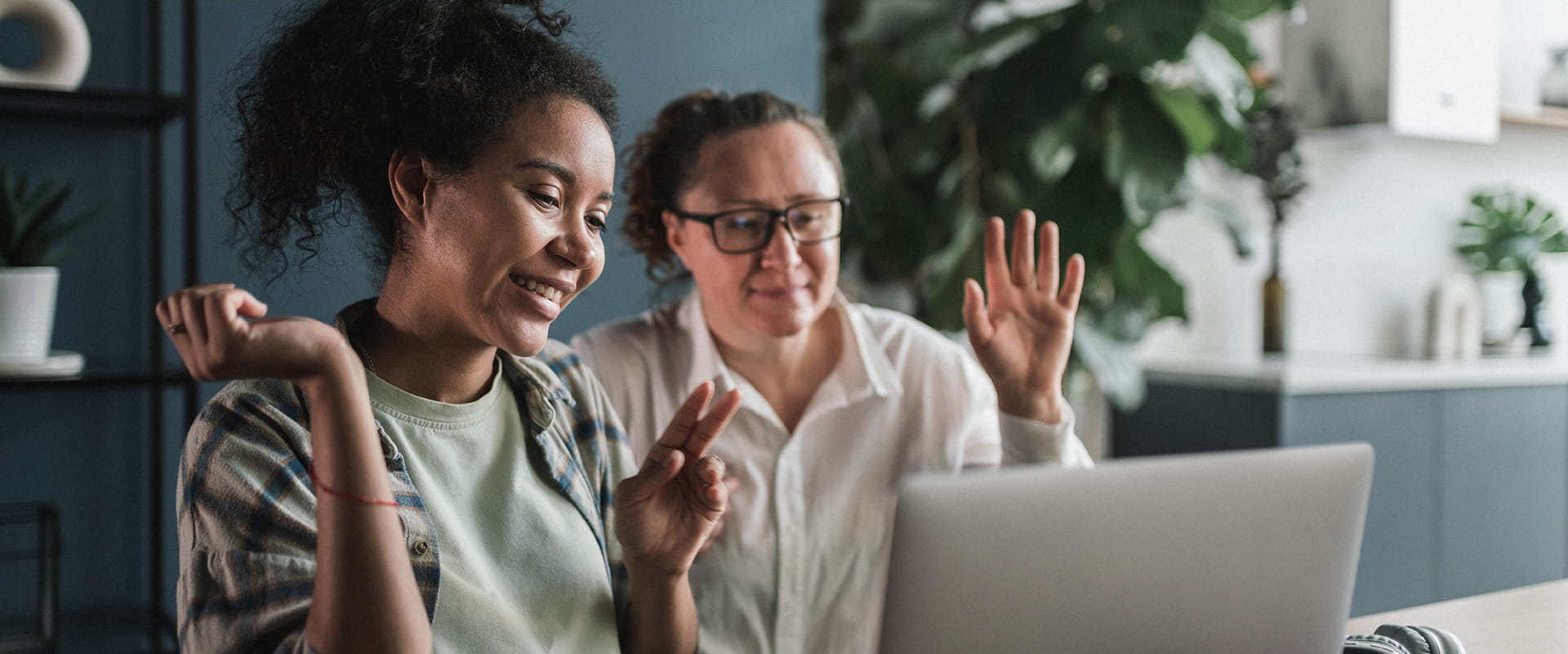 Deux personnes assises à une table utilisent un ordinateur portable pour un appel vidéo