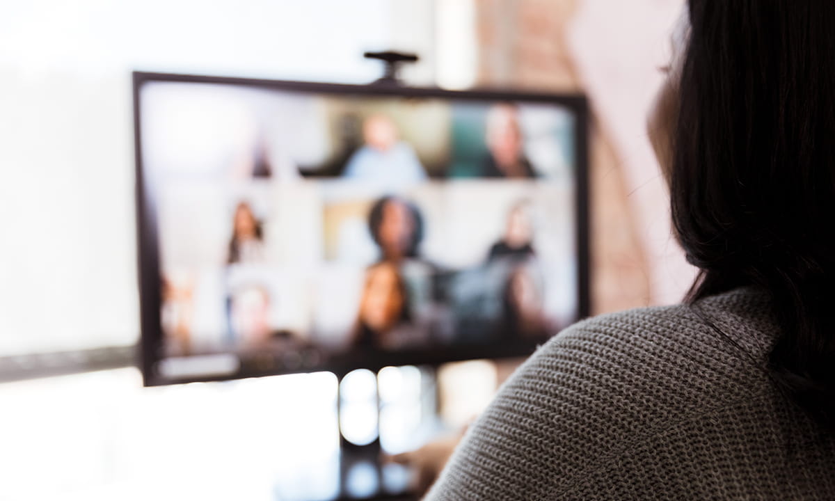 Une personne participe à une vidéoconférence avec plusieurs personnes sur un écran d'ordinateur