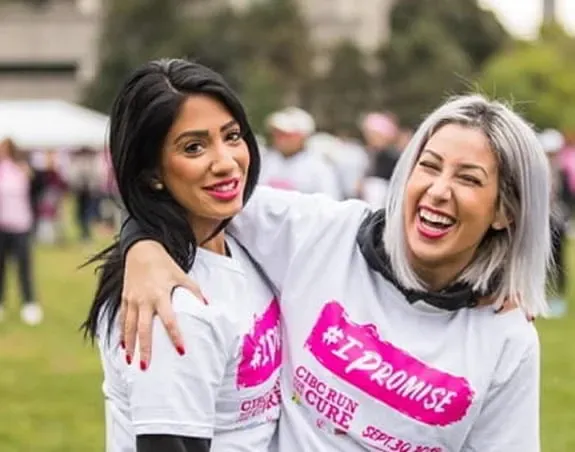 Two young women posing and wearing CIBC Run for the Cure t-shirts.