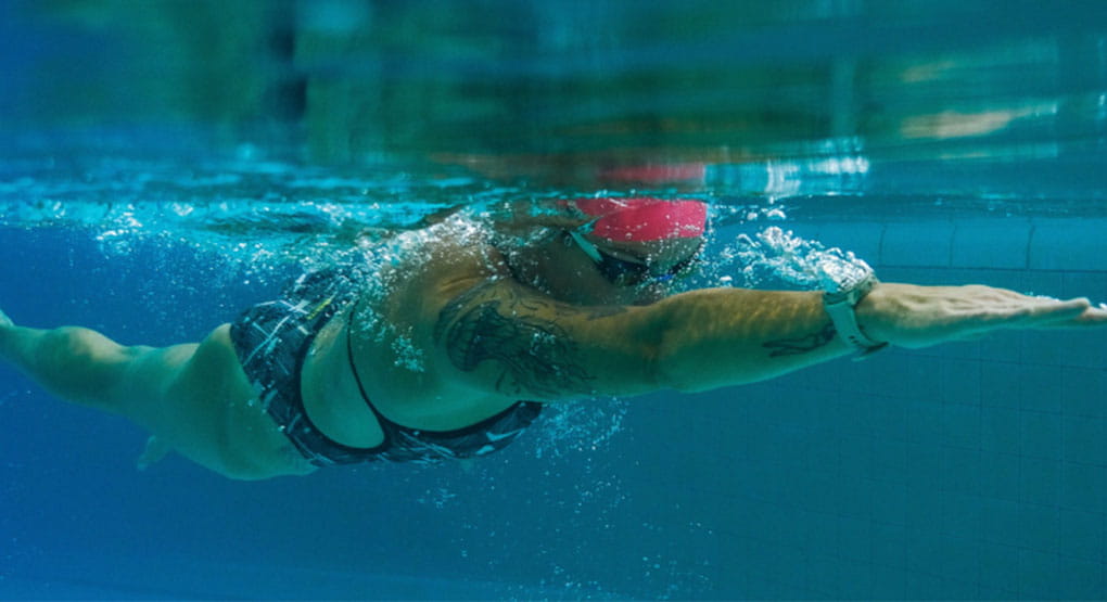 Une personne nageant sous l’eau dans une piscine.