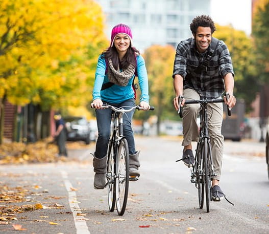Une femme et un homme font du vélo sur une route automnale 