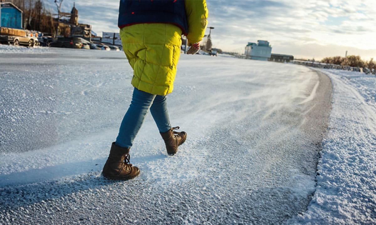 Person walking on a snow‑covered icy path