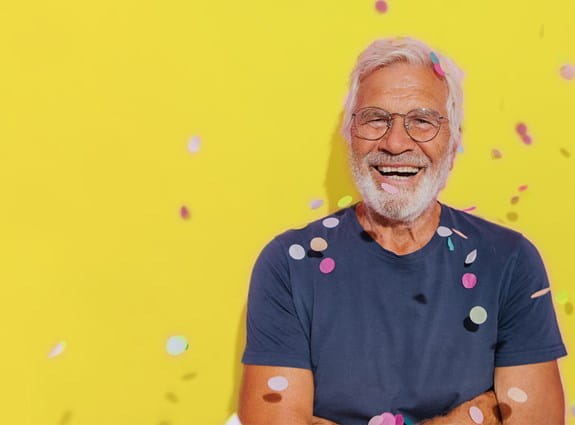 A man smiles as confetti rains down on him