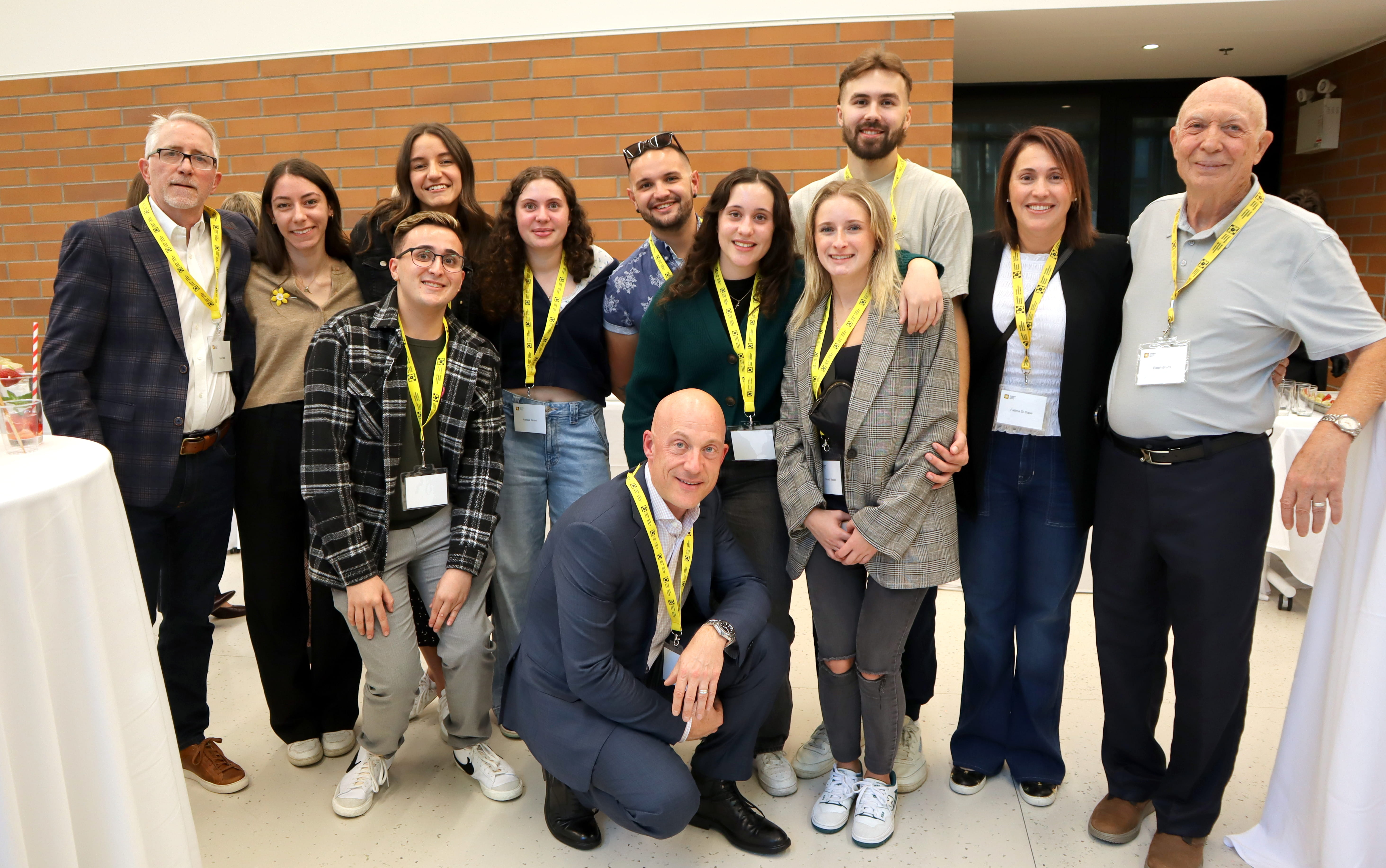 A group of people standing in an office and holding a cheque for twenty thousand seven hundred and eleven dollars. 