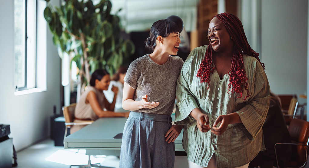 Colleagues having a casual discussion while walking through a collaborative workplace.