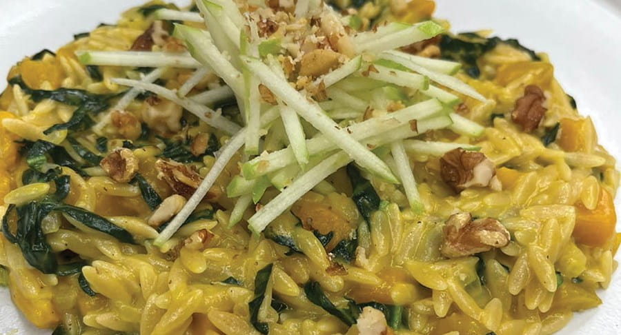Orzo à la courge musquée et aux pommes avec du grana et des noix grillés