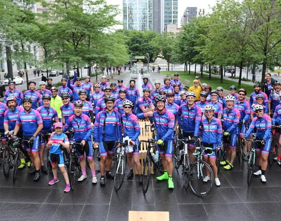 A group of Randstad Ride for Myriam cyclists smiling at the camera.