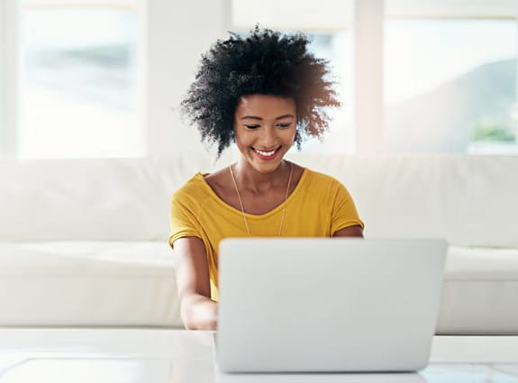 A young woman on her laptop computer in her living room