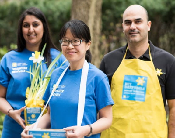 Three young Daffodil volunteers selling pins