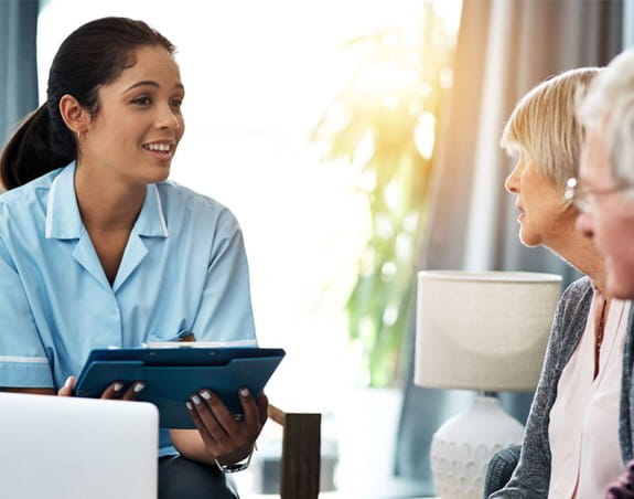 caregiver smiling at woman & man 