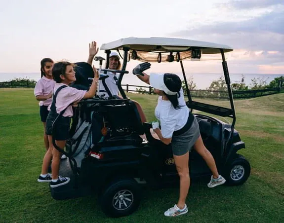 Golfers cheering around a golf cart.