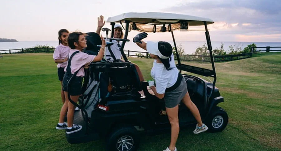 Des golfeurs se réjouissant autour d’une voiturette de golf.