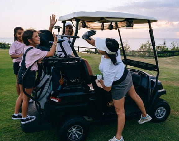 Des golfeurs se réjouissant autour d’une voiturette de golf.