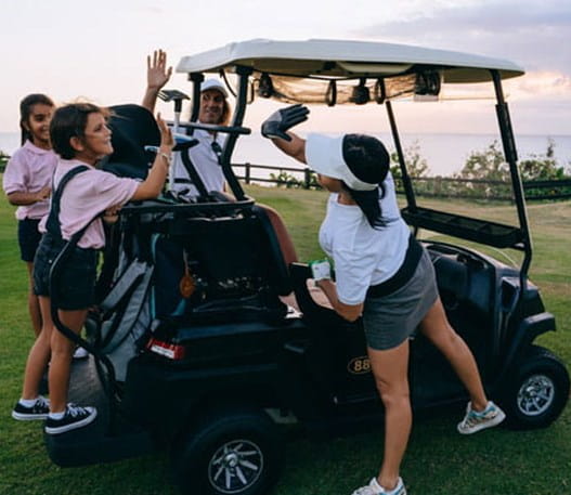 Golfers cheering around a golf cart.