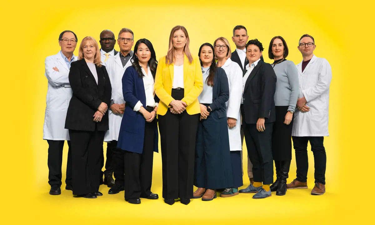 Canadian Cancer Society CEO Andrea Seale surrounded by several researchers in lab coats