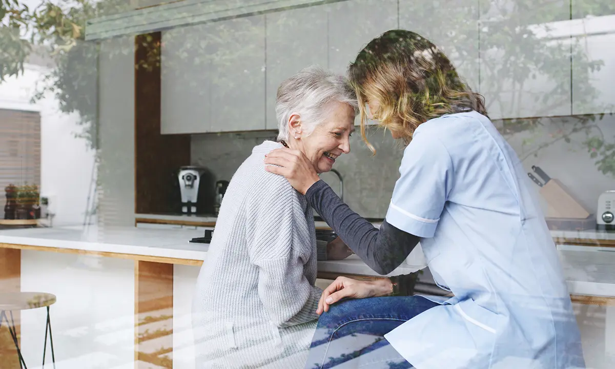 Une infirmière réconfortant une personne âgée. (It it’s a male : Un infirmier réconfortant une personne âgée.