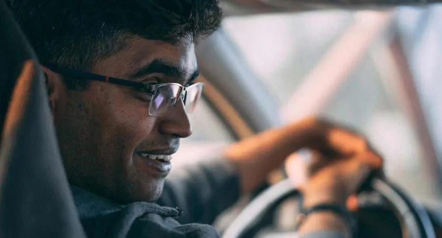 A driver looks backwards over their shoulder at the viewer