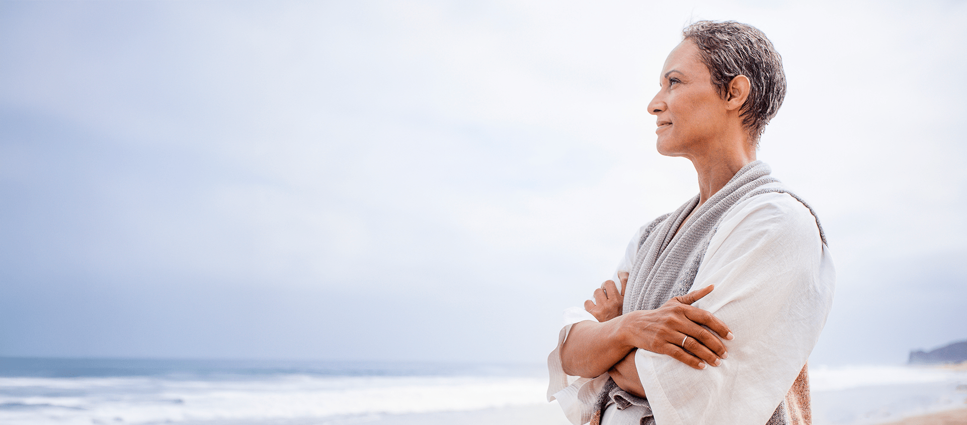 Person standing by the shoreline, gazing out over the water.