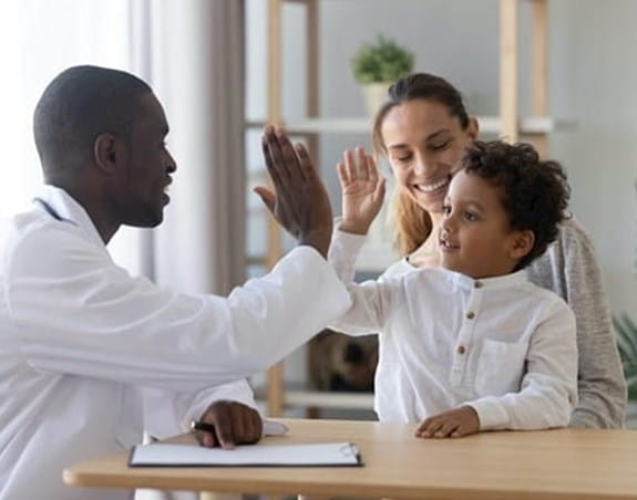 A doctor giving a child a high five