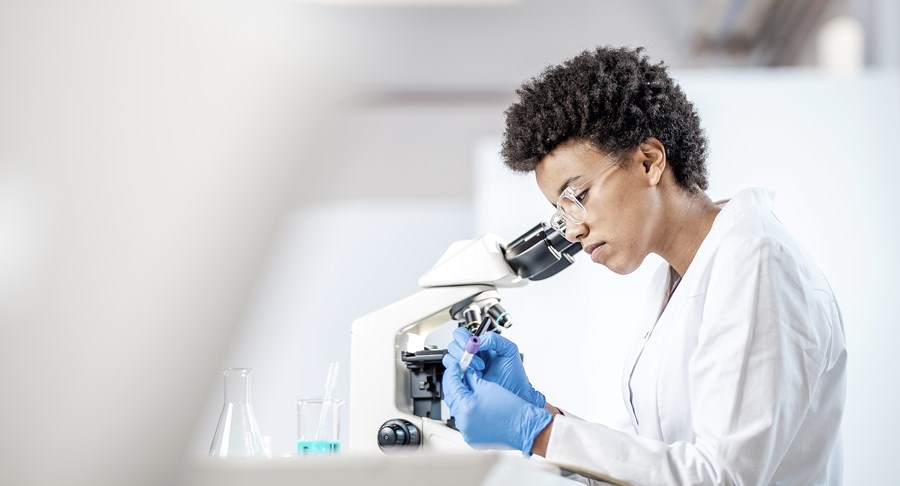 A scientist looking into a microscope.