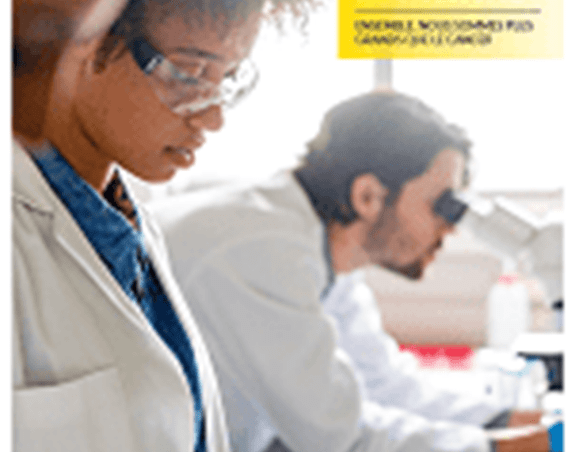 Deux scientifiques au travail à un bureau pendant qu’un troisième regarde dans un microscope.