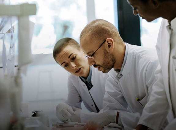 Three scientists working in a laboratory.
