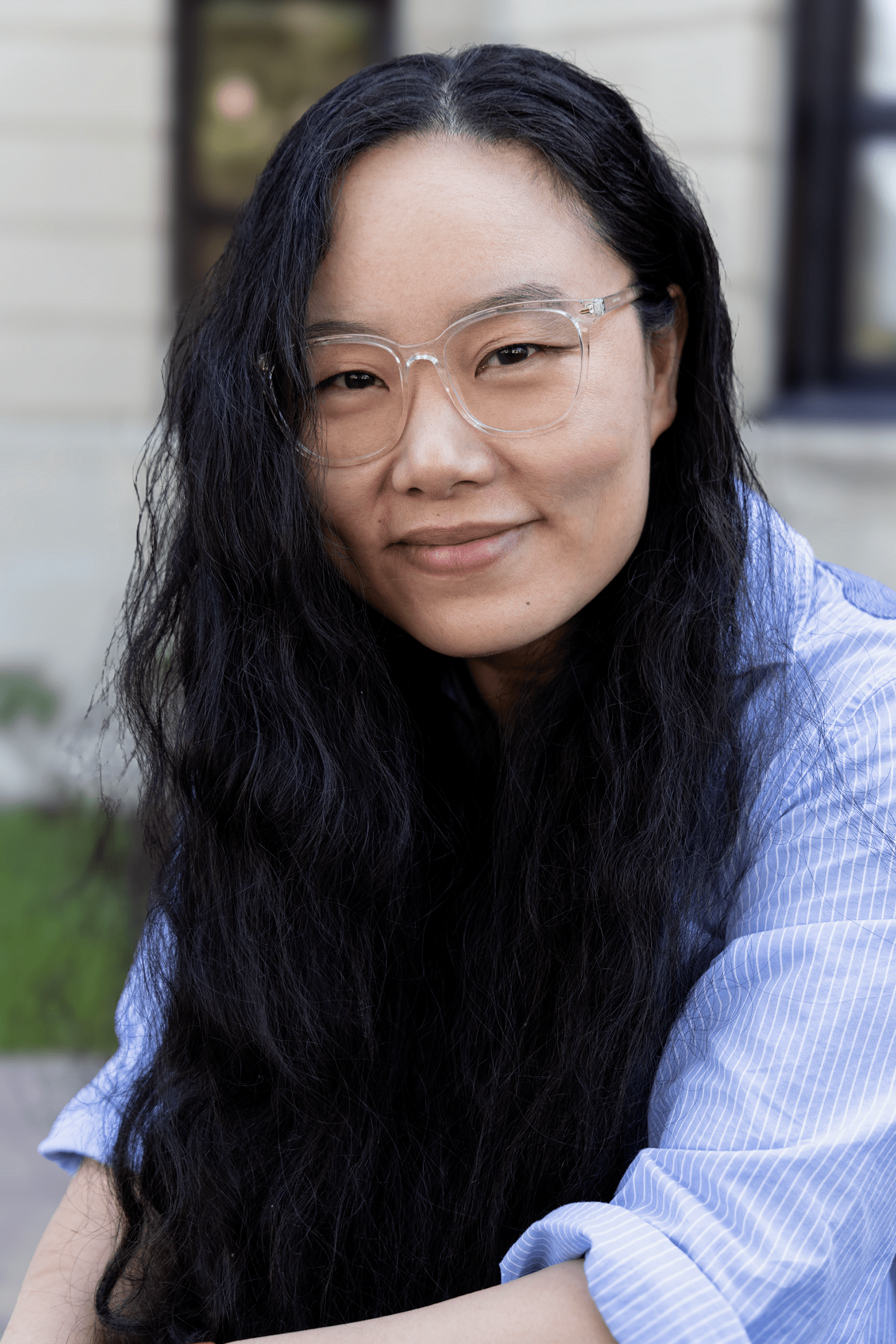 Un portrait de Lin Yang, Ph. D., une femme aux longs cheveux noirs, portant des lunettes et une chemise bleue à rayures blanches. 