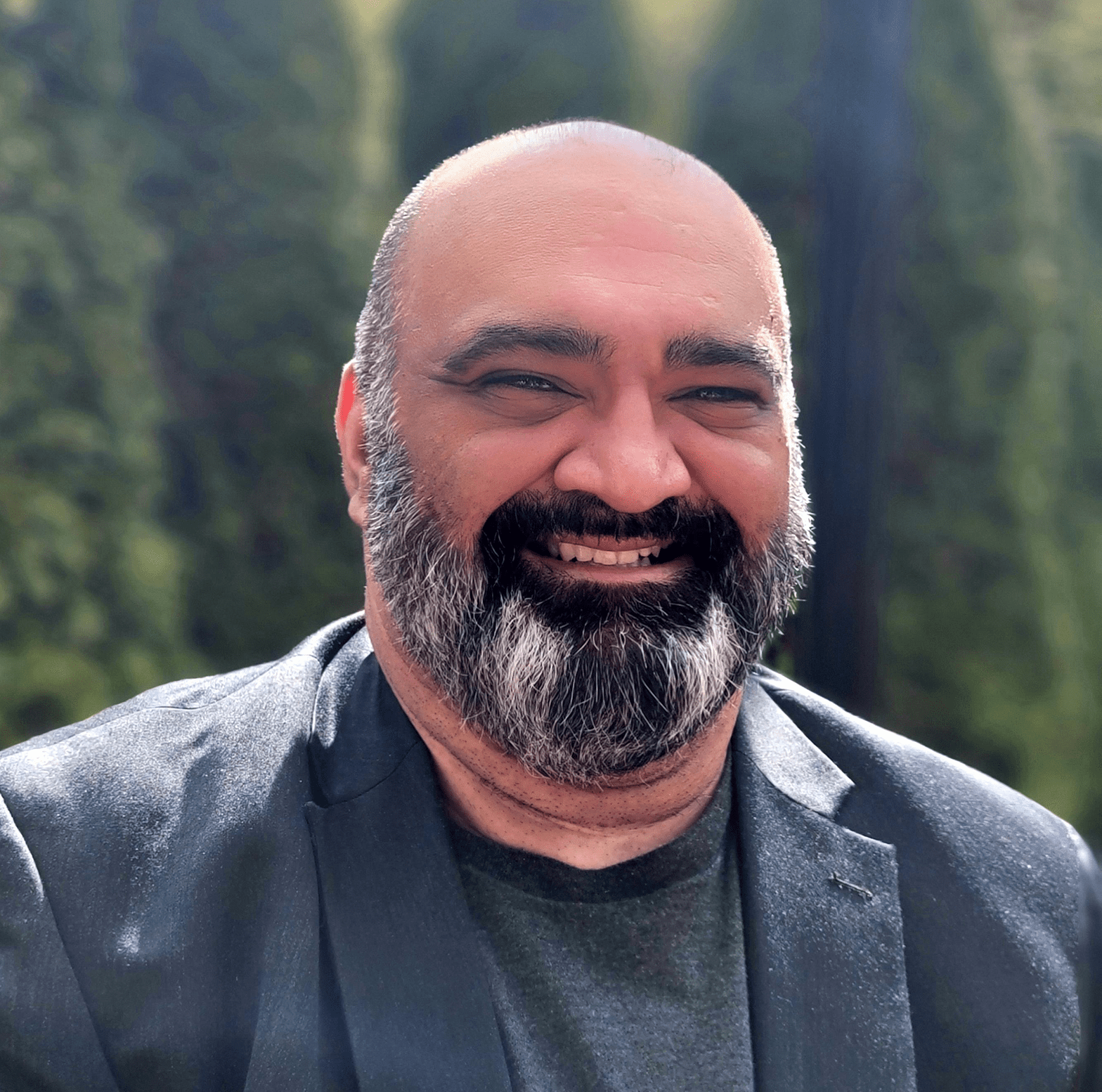 Portrait de Parveen Bhatti, Ph. D., un homme à la barbe poivre et sel, vêtu d’une chemise et d’une veste foncées. 