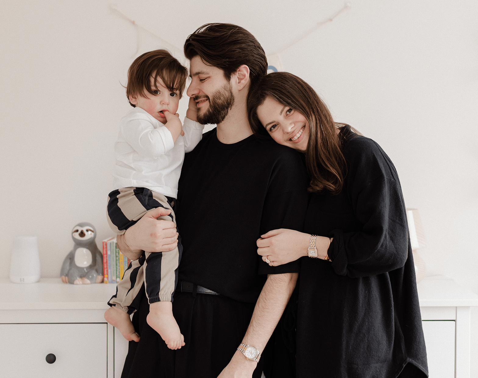 Alexandra Vacca, une jeune femme aux longs cheveux bruns, sourient en enlaçant sa famille