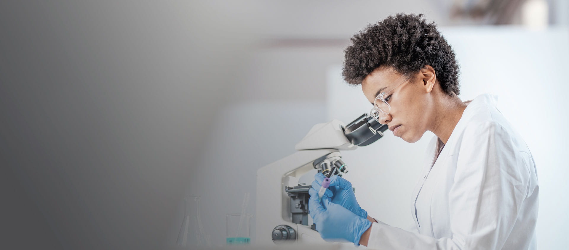 Researcher looking into a microscope in a laboratory setting   