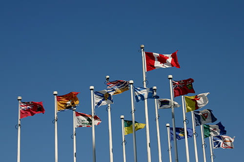 A collection of the Canadian and provincial flags waving on flagpoles