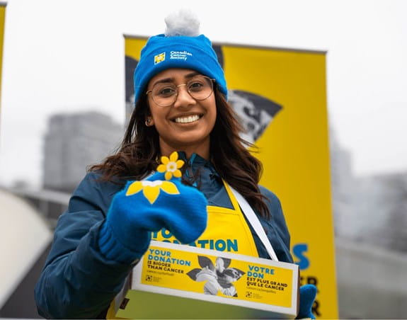 CCS staff member volunteering for Daffodil Campaign selling pins, smiling
