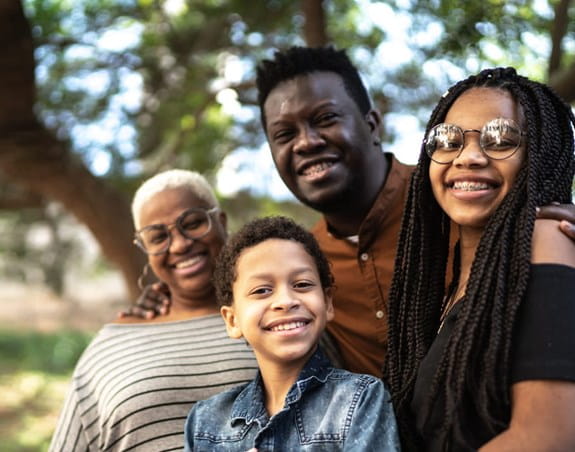 Three adults and a child smiling outdoors