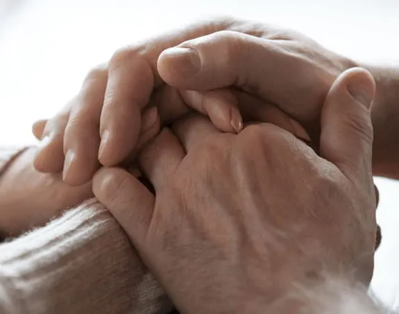 Two sets of hands clasped together