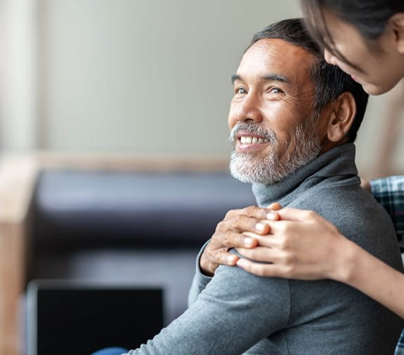 An older man holds the hand of a younger man looking over his shoulder.