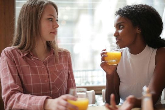 Two women talking while sitting at a table