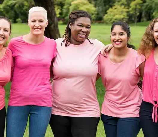 Five women dressed in pink stand together  