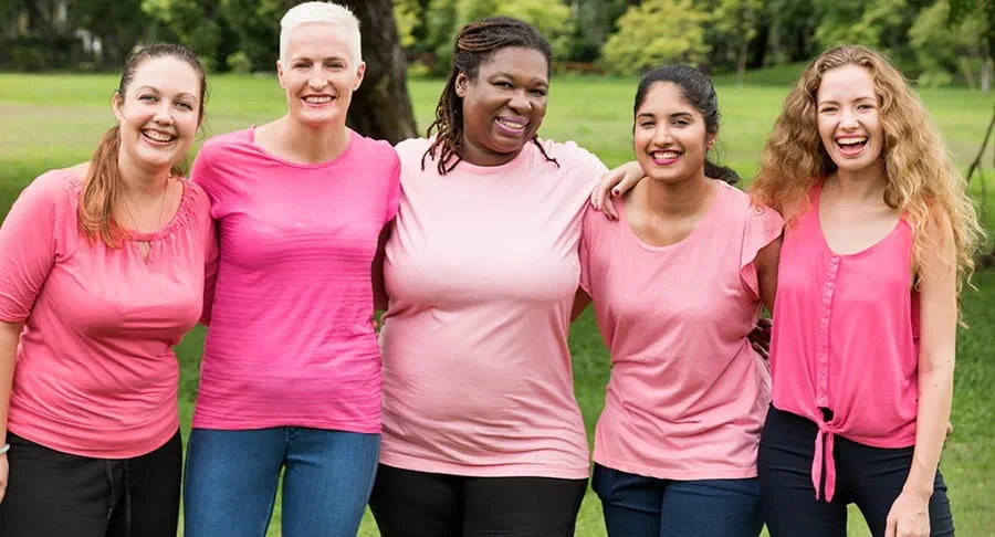 Five women dressed in pink stand together