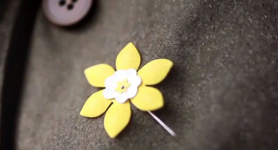 A yellow daffodil pin on a person’s shirt