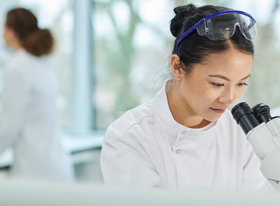 A researcher looking into a microscope